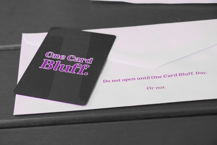 A One Card Bluff. playing card, with the back facing you, on top of an envelope that reads 'Do not open until One Card Bluff. Day. Or not.'